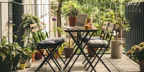 Cozy balcony with plants, a small table, and a chair